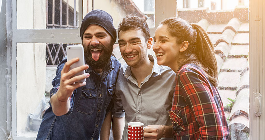 Three friends take a Selfie with phone